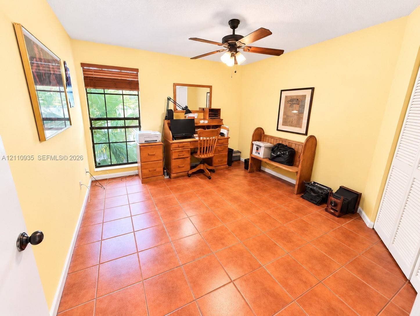 3530 Magellan Circle, #618, Aventura, FL 33180 Ceramic tile flooring, multi-pane window with wood-finish blinds, ceiling fan with integrated light fixture, and louvered closet doors