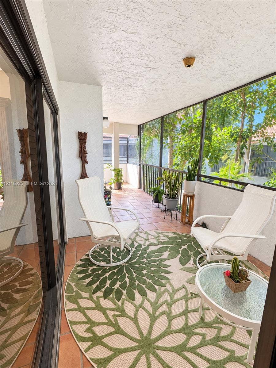 3530 Magellan Circle, #618, Aventura, FL 33180 Screened-in balcony featuring tile flooring, metal railings, and sliding glass door entry