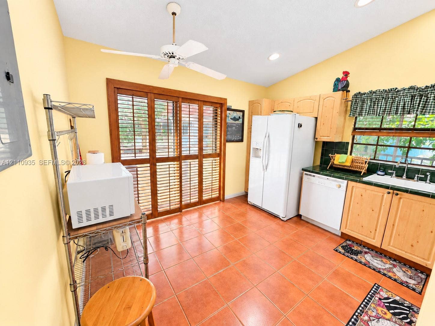 3530 Magellan Circle, #618, Aventura, FL 33180 Kitchen featuring ceramic tile flooring, light wood cabinetry, built-in recessed lighting, white appliances, and wood-framed sliding glass doors