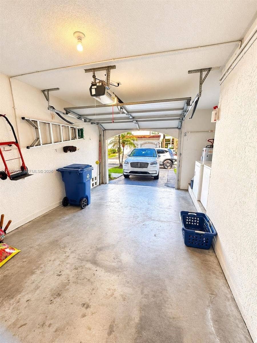 3530 Magellan Circle, #618, Aventura, FL 33180 Enclosed one-car garage featuring a concrete floor, automated overhead garage door system, and textured wall finish