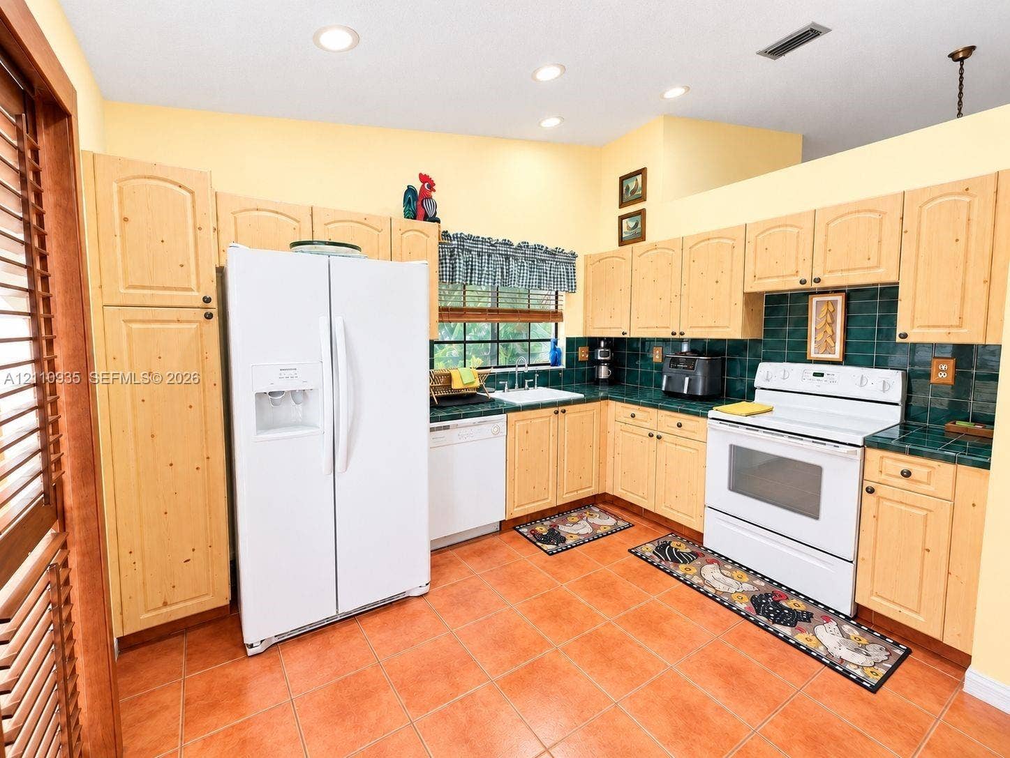 3530 Magellan Circle, #618, Aventura, FL 33180 Kitchen featuring light wood-finish cabinetry, emerald green tile backsplash and countertops, ceramic tile flooring, and recessed lighting