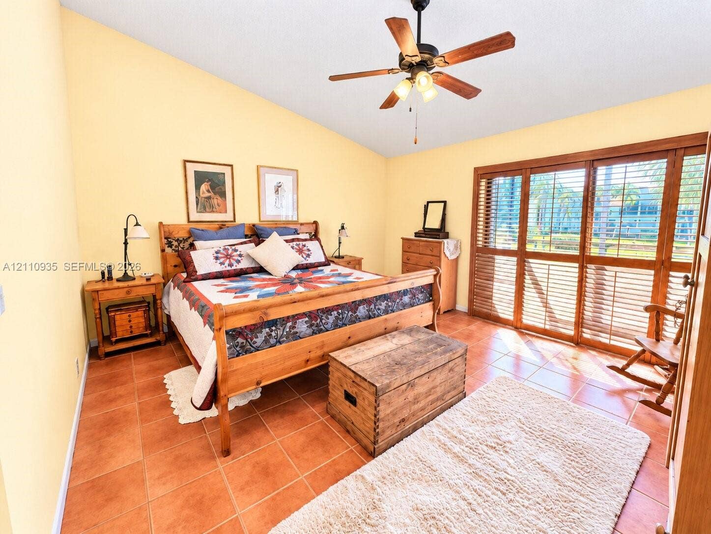 3530 Magellan Circle, #618, Aventura, FL 33180 Vaulted ceilings, terra cotta tile flooring, and floor-to-ceiling wooden-frame sliding glass doors featuring integrated shutters and a central ceiling fan with multi-light fixture