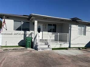 Single-story exterior featuring a covered front porch, white railings, concrete steps, and a concrete driveway