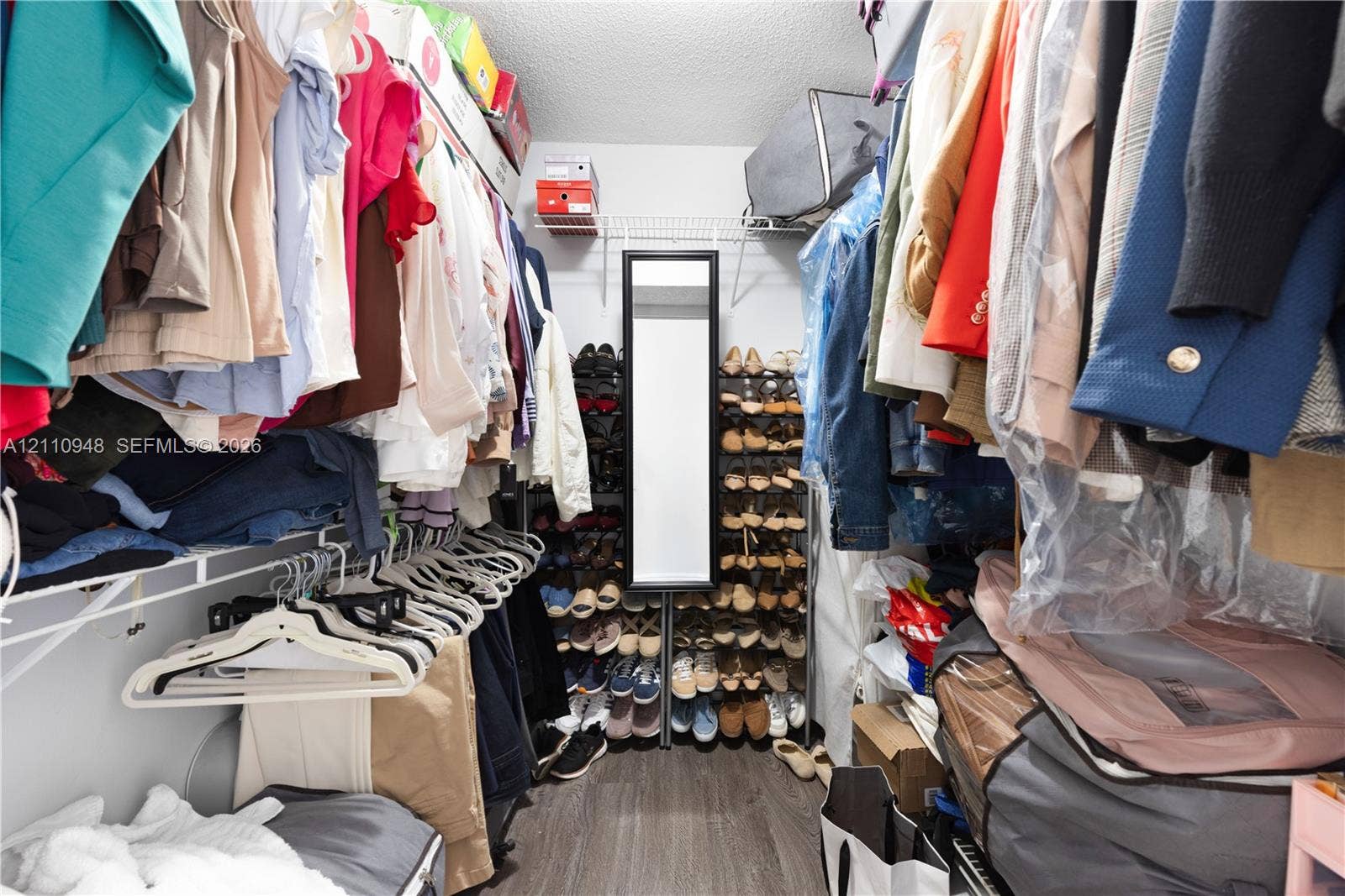 Walk-in storage space featuring wood-finish flooring and wire shelving systems
