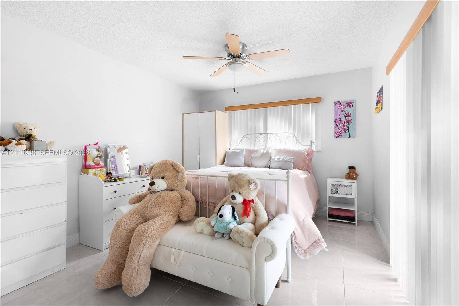 Neutral-toned tiled flooring, ceiling fan with light fixture, and vertical window blinds