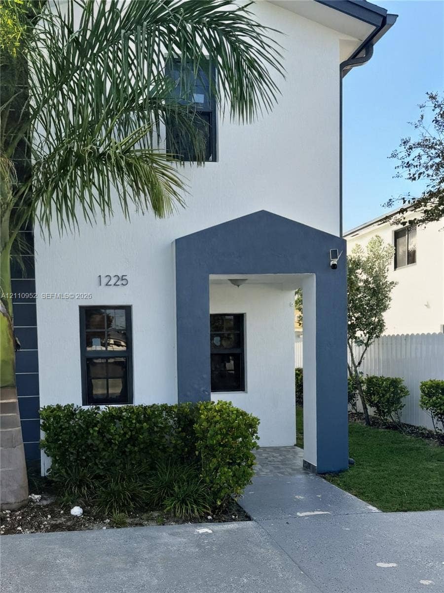 1225 NW 9 Avenue, #0, Florida City, Florida City, FL 33034 Stucco exterior featuring contrasting trim, a covered entryway, multi-pane windows, and concrete driveway