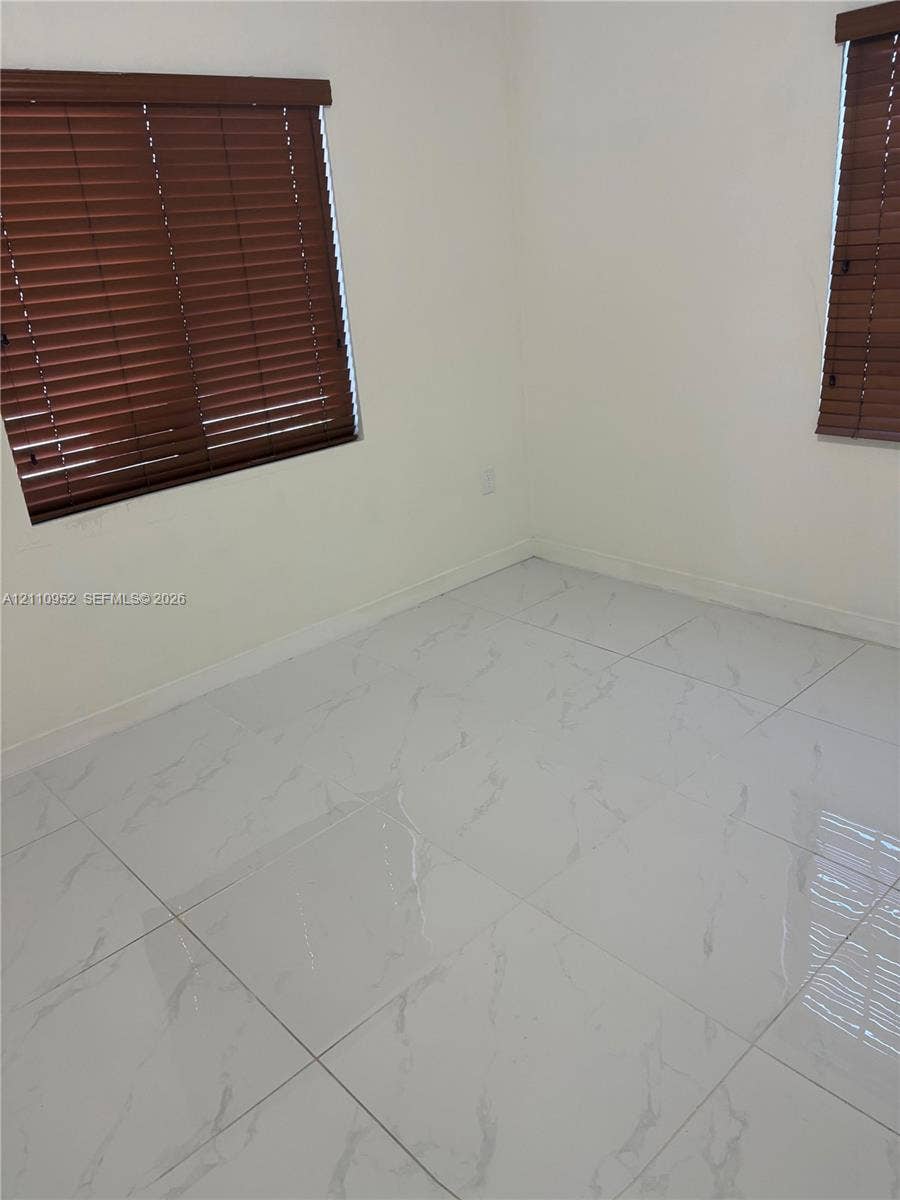 1225 NW 9 Avenue, #0, Florida City, Florida City, FL 33034 Large-format stone-style tile flooring with neutral wall finishes, paired with two windows featuring horizontal wood-finish blinds
