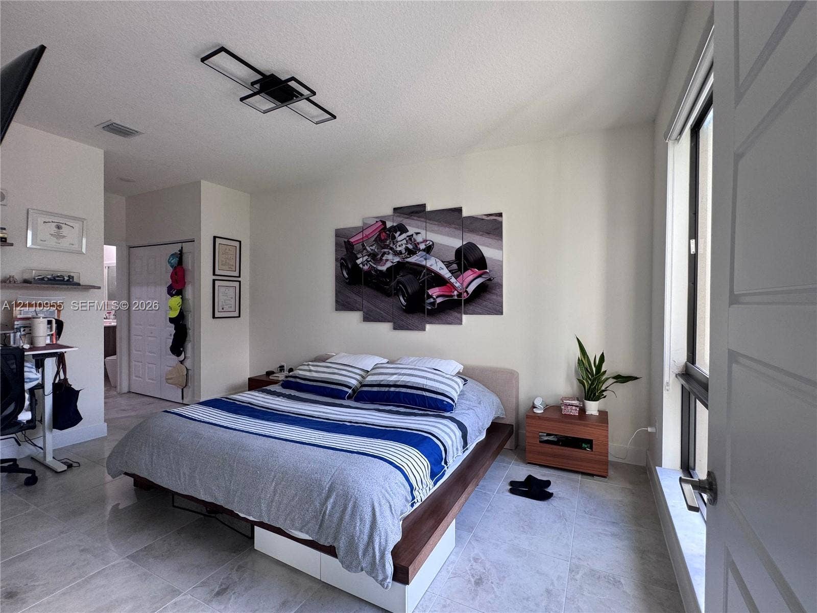 4636 NW 84th Avenue, #35, Doral, FL 33166 Neutral tile flooring, modern rectangular geometric ceiling light fixture, sliding panel closet doors, and large windows with exterior exposure