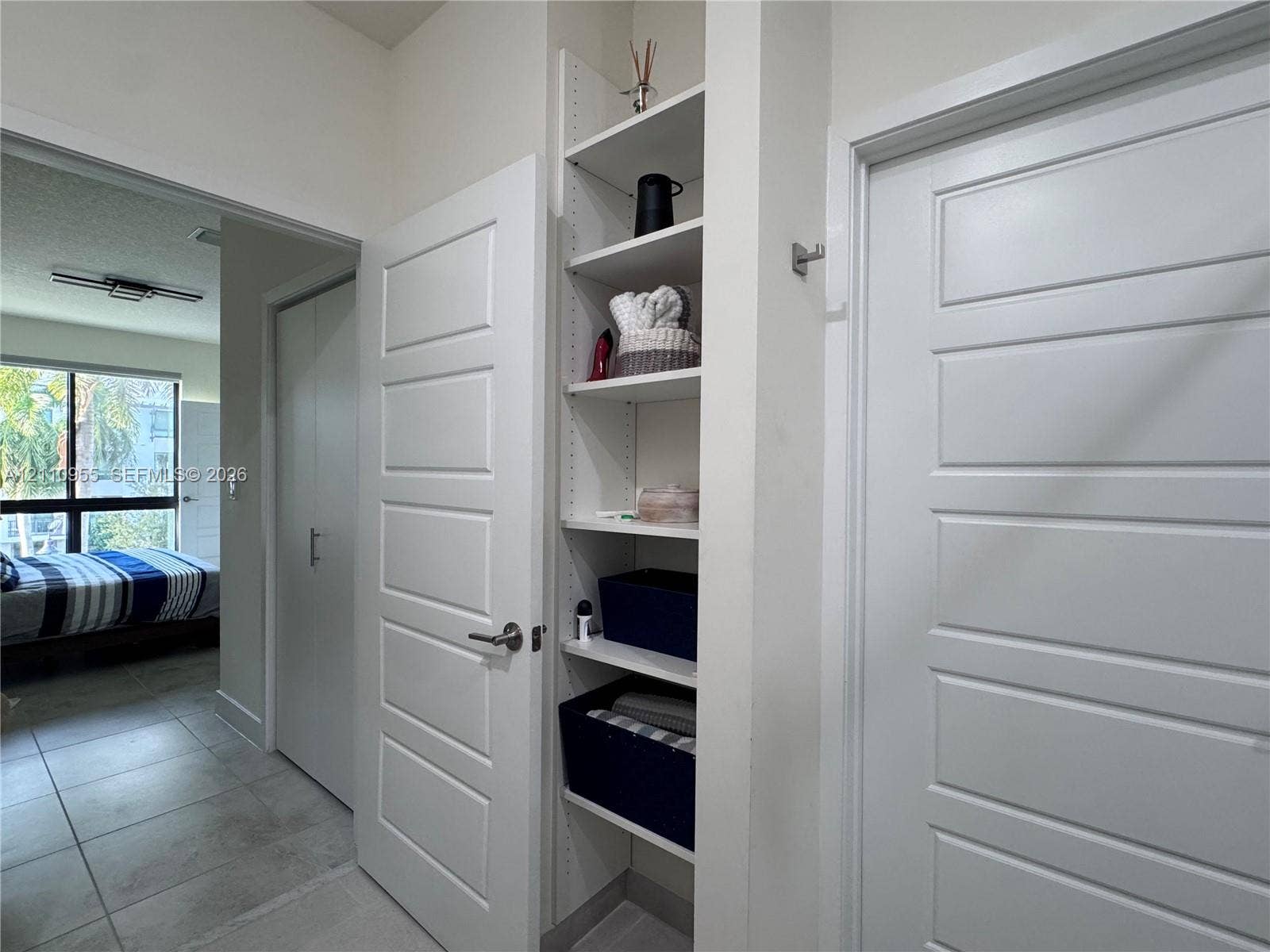 4636 NW 84th Avenue, #35, Doral, FL 33166 Built-in white shelving unit, four-panel interior doors, and tile flooring
