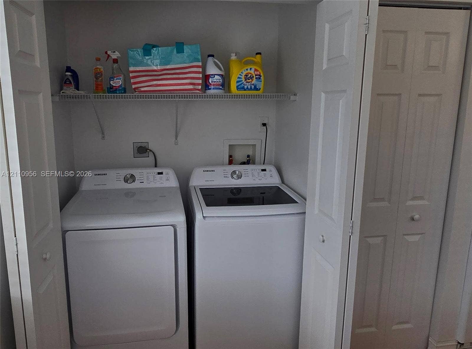 2120 SW 94th Terrace, #404, Davie, FL 33324 Laundry closet featuring white bifold doors and a metal wire shelving unit