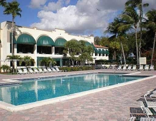 2120 SW 94th Terrace, #404, Davie, FL 33324 Rectangular swimming pool with stone-paver decking and mature palm trees
