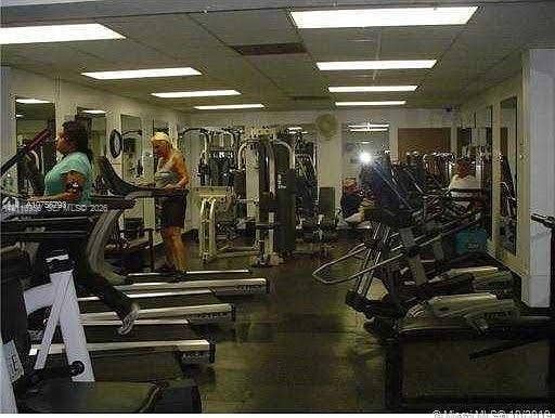 2120 SW 94th Terrace, #404, Davie, FL 33324 Fitness center featuring drop-ceiling panels, recessed fluorescent lighting, and wall-to-wall mirrors