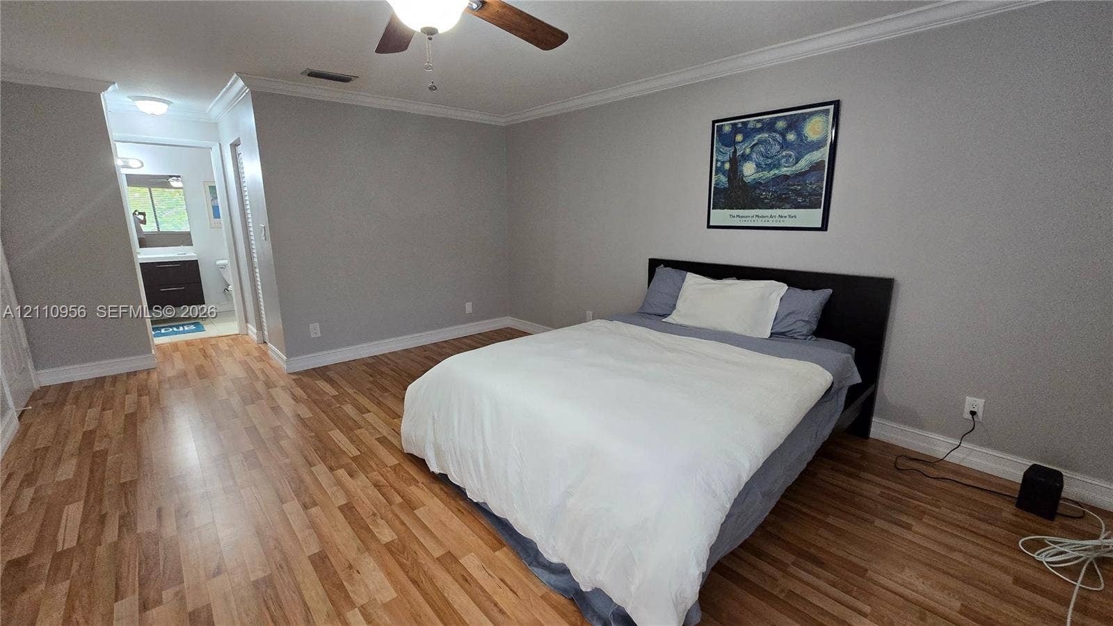 2120 SW 94th Terrace, #404, Davie, FL 33324 Neutral-toned bedroom featuring wood-finish flooring, crown molding, and a ceiling fan with integrated lighting