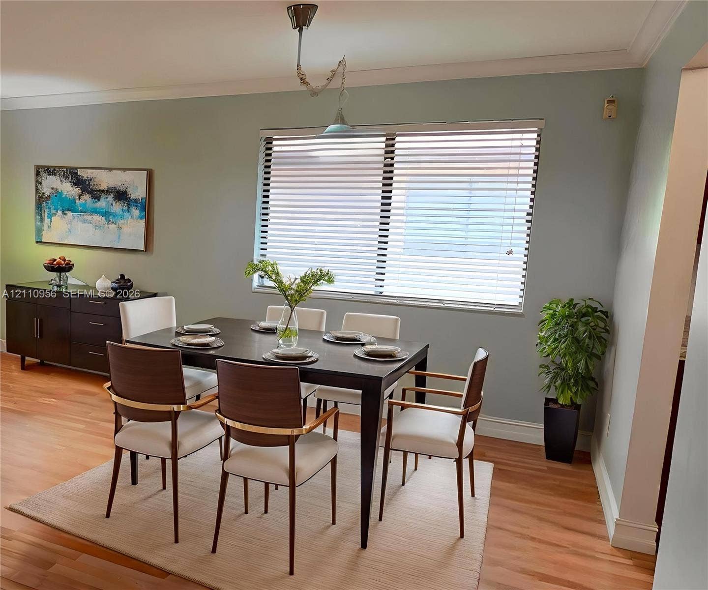 2120 SW 94th Terrace, #404, Davie, FL 33324 Dining area featuring wood-finish flooring, crown molding, a large window with horizontal blinds, and a suspended pendant light fixture