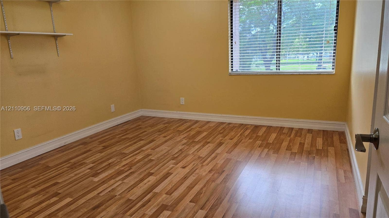 2120 SW 94th Terrace, #404, Davie, FL 33324 Wood-finish flooring, wall-mounted shelving, and horizontal window blinds