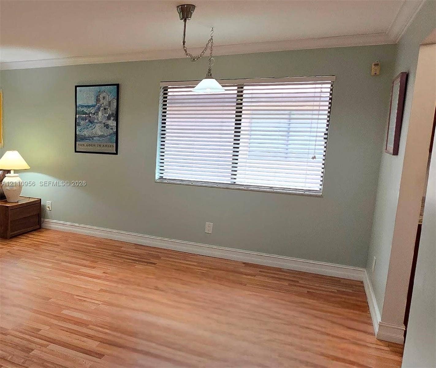 2120 SW 94th Terrace, #404, Davie, FL 33324 Living area featuring wood-finish flooring, crown molding, and a central pendant light fixture