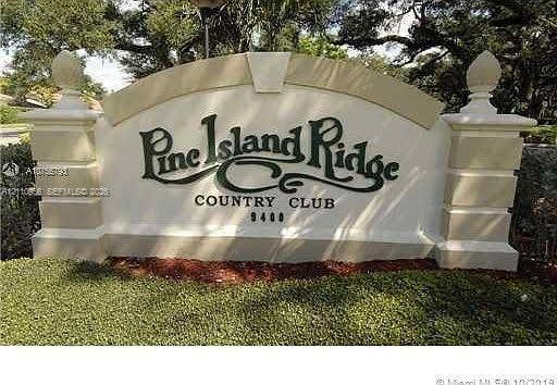 2120 SW 94th Terrace, #404, Davie, FL 33324 Stucco monument sign featuring decorative finials, tiered masonry pillars, and mature landscaping