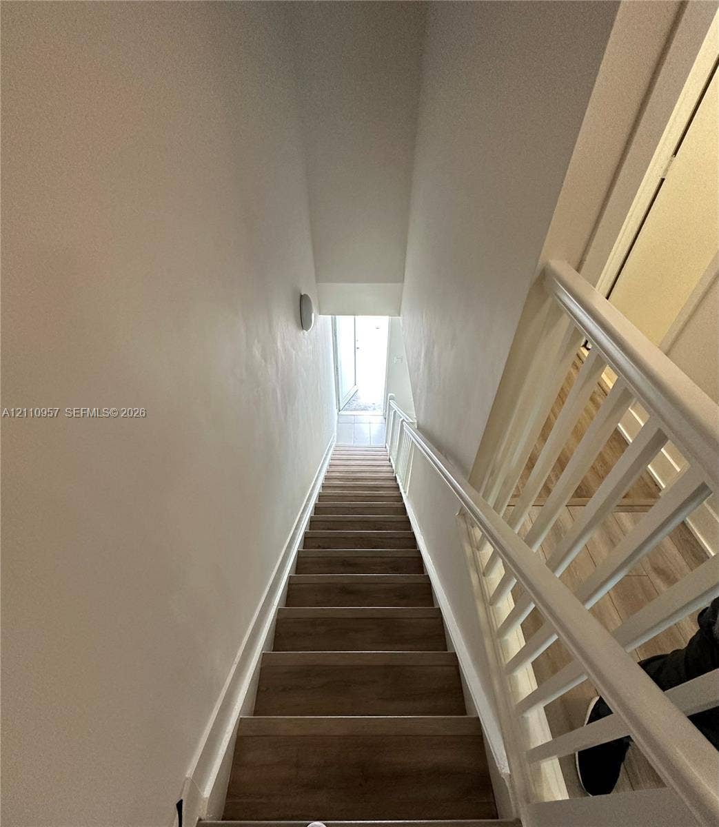 12115 NE 5th Avenue, #12115, North Miami, North Miami, FL 33161 Staircase featuring wood-finish treads and white painted handrails with vertical balusters