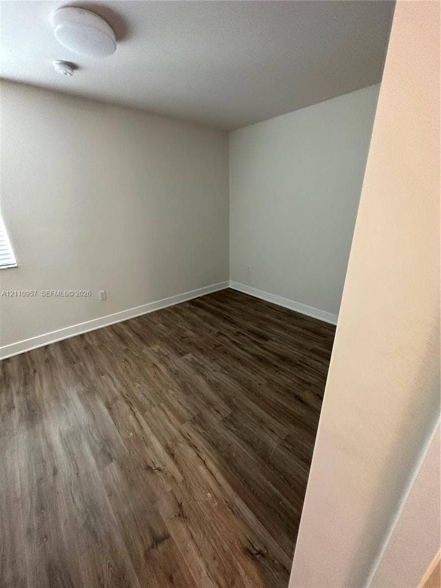 12115 NE 5th Avenue, #12115, North Miami, North Miami, FL 33161 Room with wood-finish flooring, neutral-toned walls, and a ceiling-mounted light fixture
