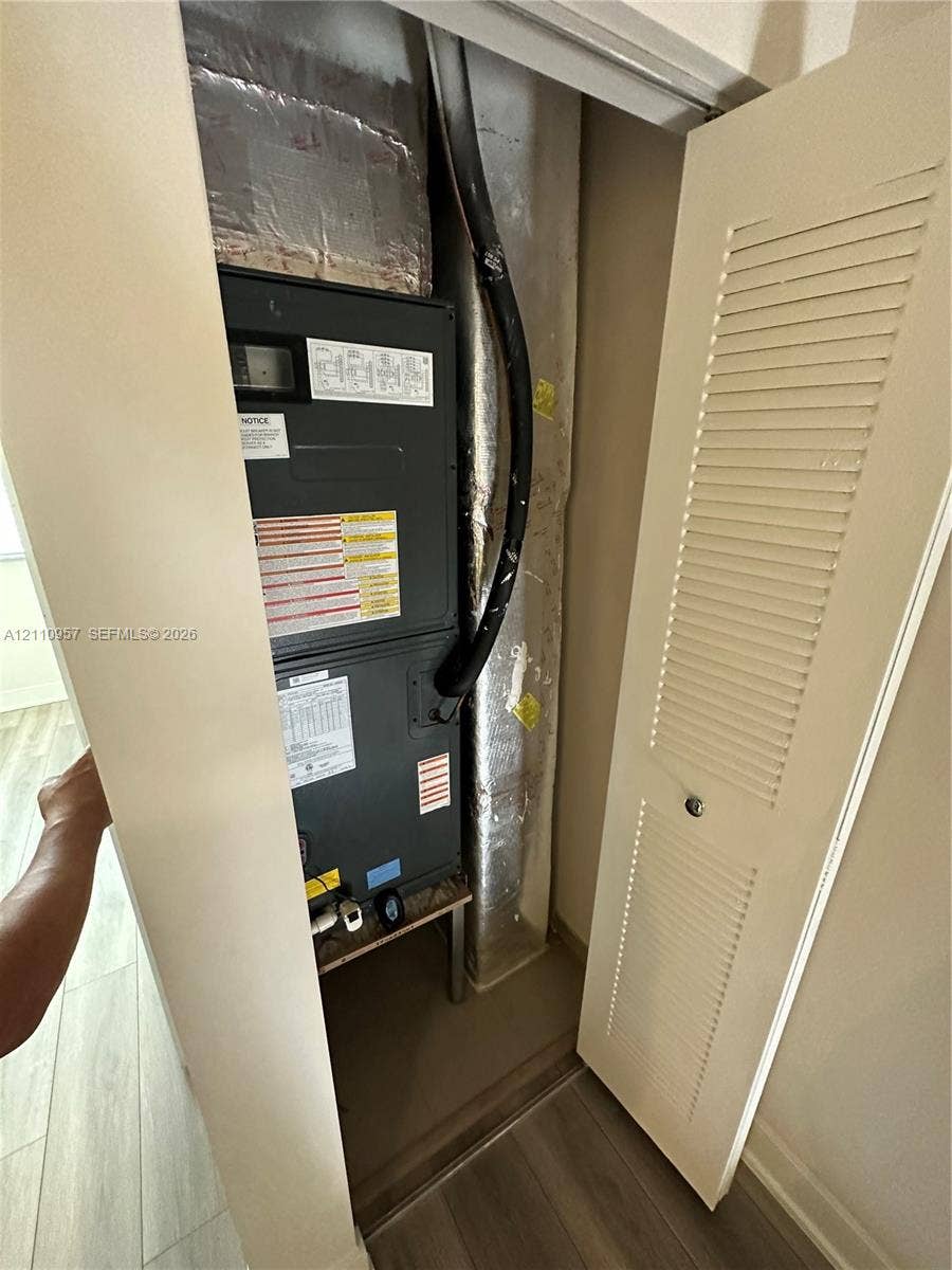 12115 NE 5th Avenue, #12115, North Miami, North Miami, FL 33161 Mechanical closet featuring a vertical furnace unit with attached insulated ductwork and a louvered bi-fold door