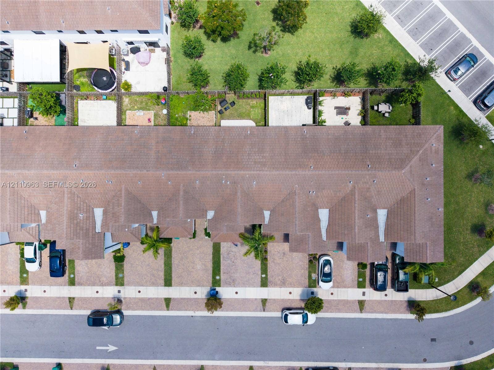 23436 SW 129th Avenue, #23436, Homestead, Homestead, FL 33032 Aerial perspective of a multi-unit property featuring a shingled hip roof, paved driveways, and private fenced rear patios