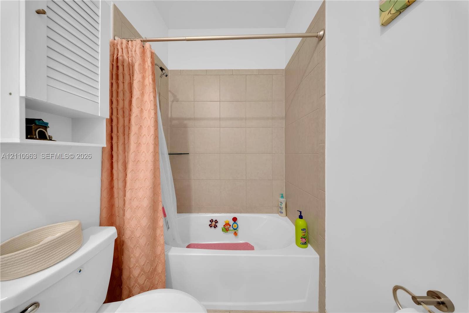 23436 SW 129th Avenue, #23436, Homestead, Homestead, FL 33032 Bathroom featuring a tub with a tile surround, a built-in shutter-style wall cabinet, and metallic hardware