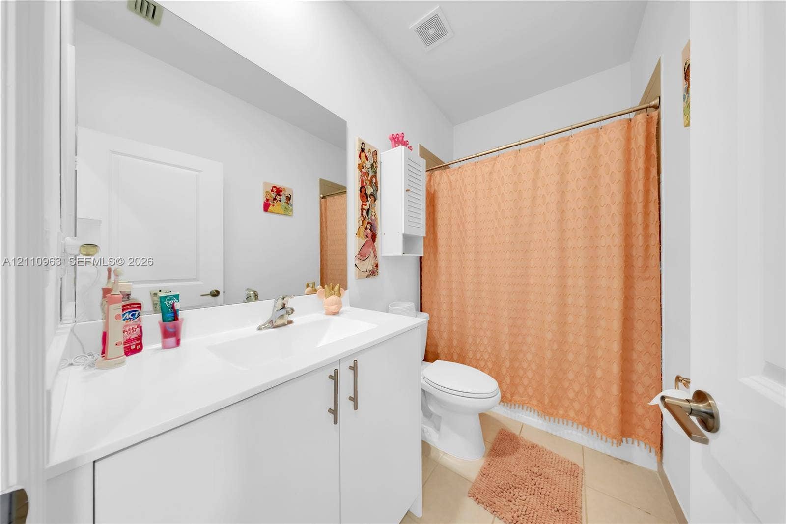23436 SW 129th Avenue, #23436, Homestead, Homestead, FL 33032 Bathroom featuring a white vanity cabinet with a solid surface countertop, an integrated sink, a full-width wall mirror, and a tub-shower combination with a shower rod
