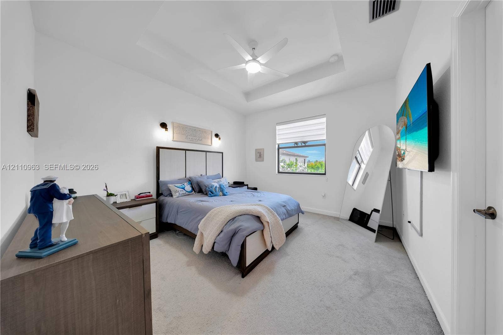 23436 SW 129th Avenue, #23436, Homestead, Homestead, FL 33032 Tray ceiling with central paddle fan, wall-mounted light fixtures, and neutral carpeting