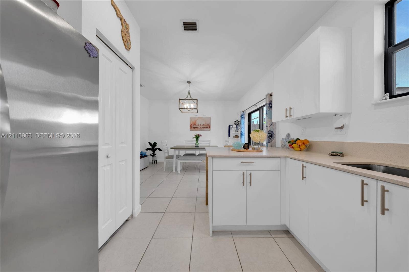 23436 SW 129th Avenue, #23436, Homestead, Homestead, FL 33032 Kitchen featuring white cabinetry, stainless steel appliances, solid surface countertops, tile flooring, and a pendant light fixture