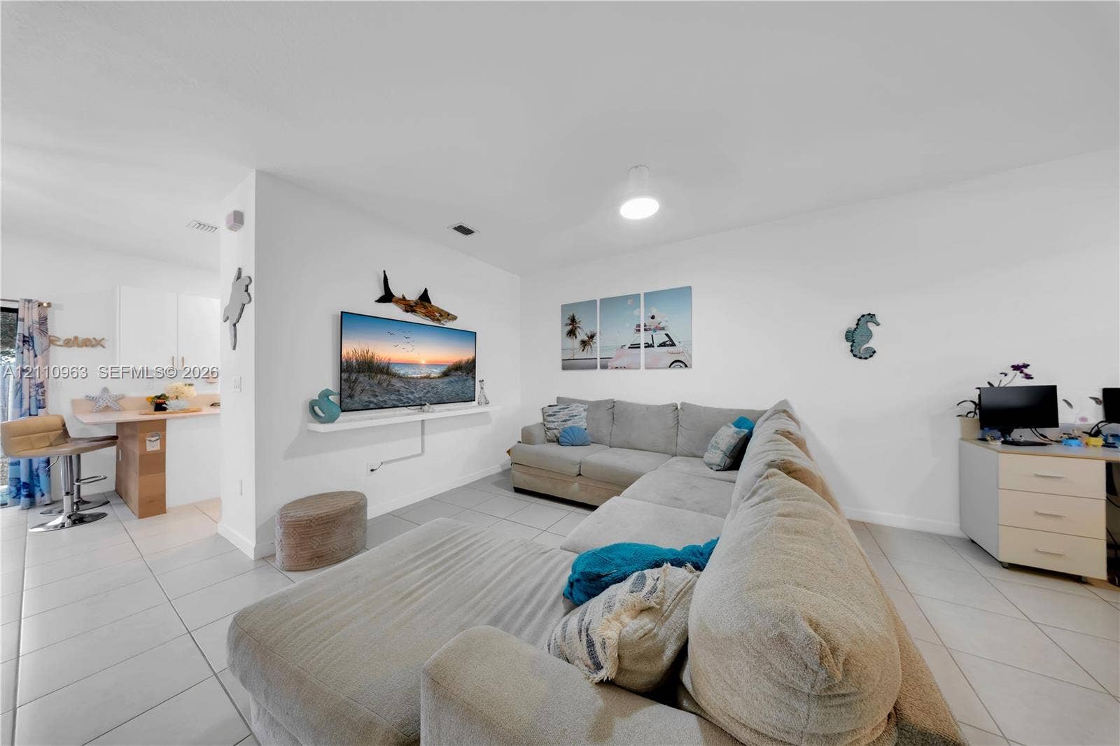 23436 SW 129th Avenue, #23436, Homestead, Homestead, FL 33032 Open-concept space featuring light-toned tile flooring, recessed ceiling lighting, a wall-mounted display shelf, and a built-in kitchen peninsula with a countertop