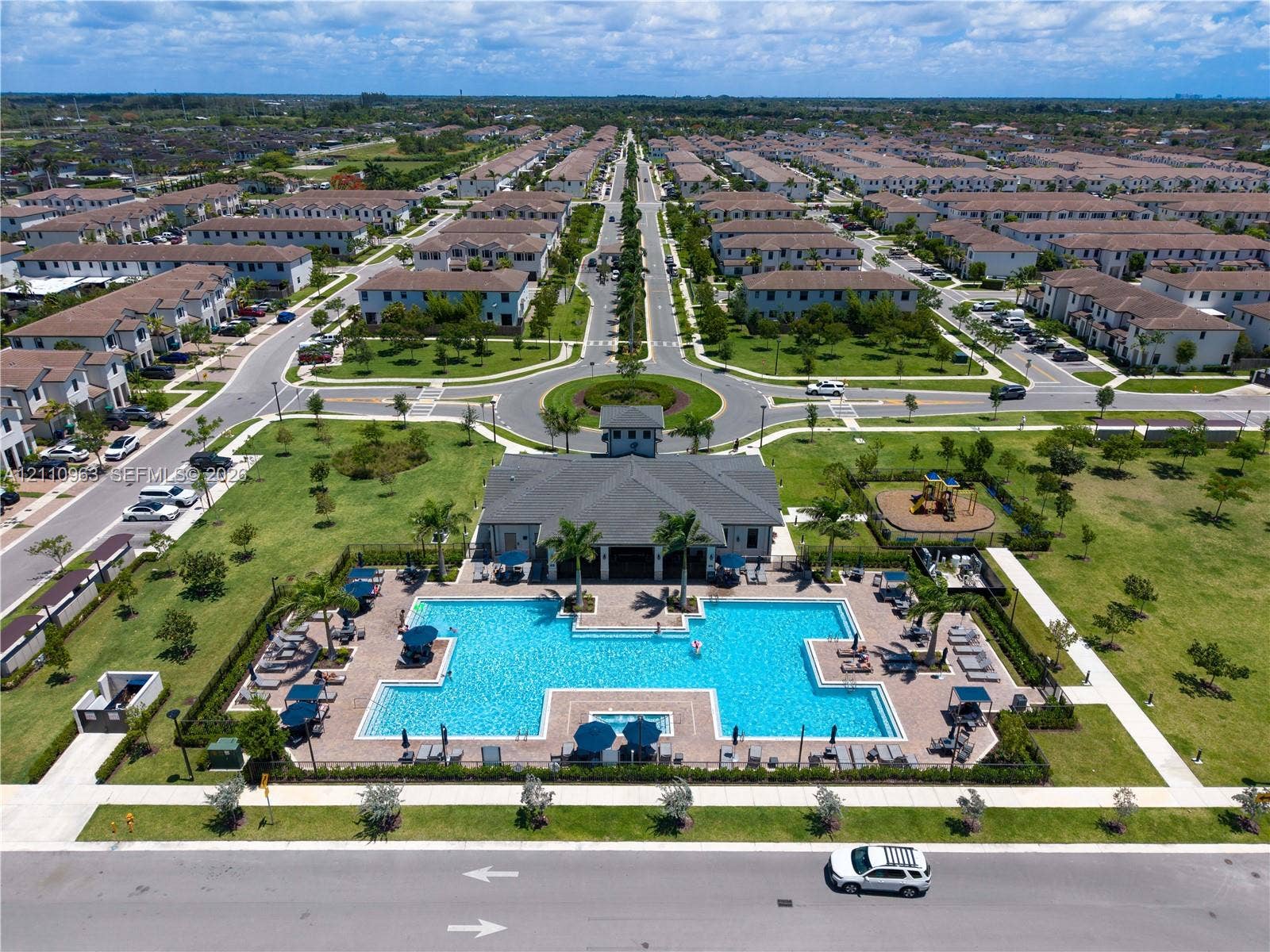 23436 SW 129th Avenue, #23436, Homestead, Homestead, FL 33032 Community recreation center featuring an expansive swimming pool, paver deck, clubhouse building, and playground area