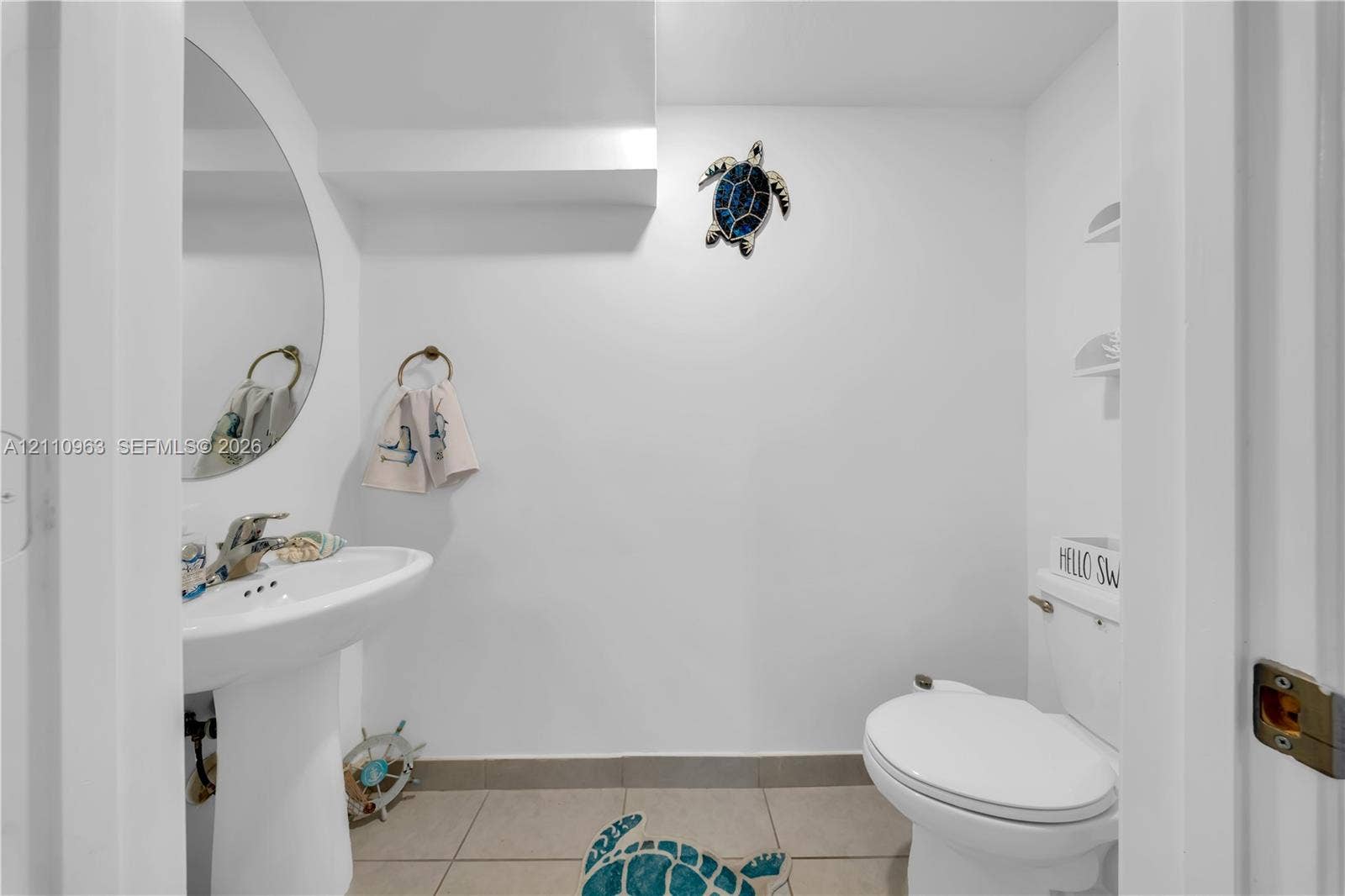 23436 SW 129th Avenue, #23436, Homestead, Homestead, FL 33032 Powder room featuring a pedestal sink, arched wall mirror, ceramic tile flooring, and integrated shelving