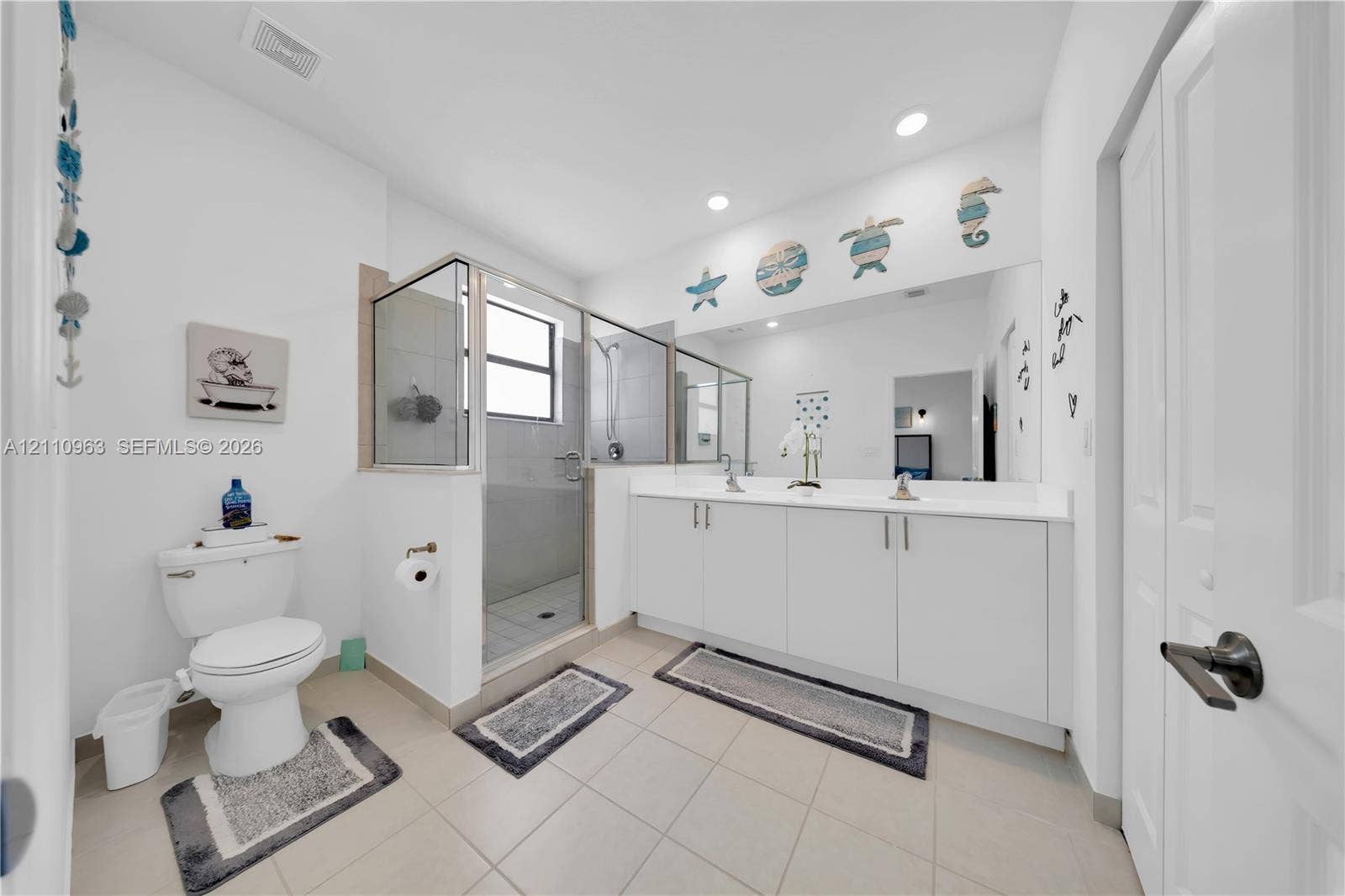 23436 SW 129th Avenue, #23436, Homestead, Homestead, FL 33032 Bathroom featuring a double-sink vanity with white cabinetry and a full-width wall mirror, walk-in shower with a glass enclosure, and neutral tile flooring