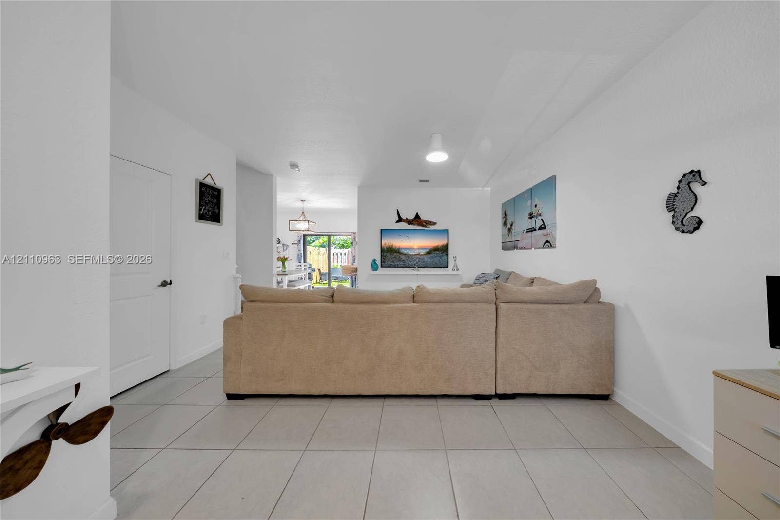 23436 SW 129th Avenue, #23436, Homestead, Homestead, FL 33032 Open-concept interior featuring large-format neutral floor tile, a recessed wall niche, and sliding glass doors