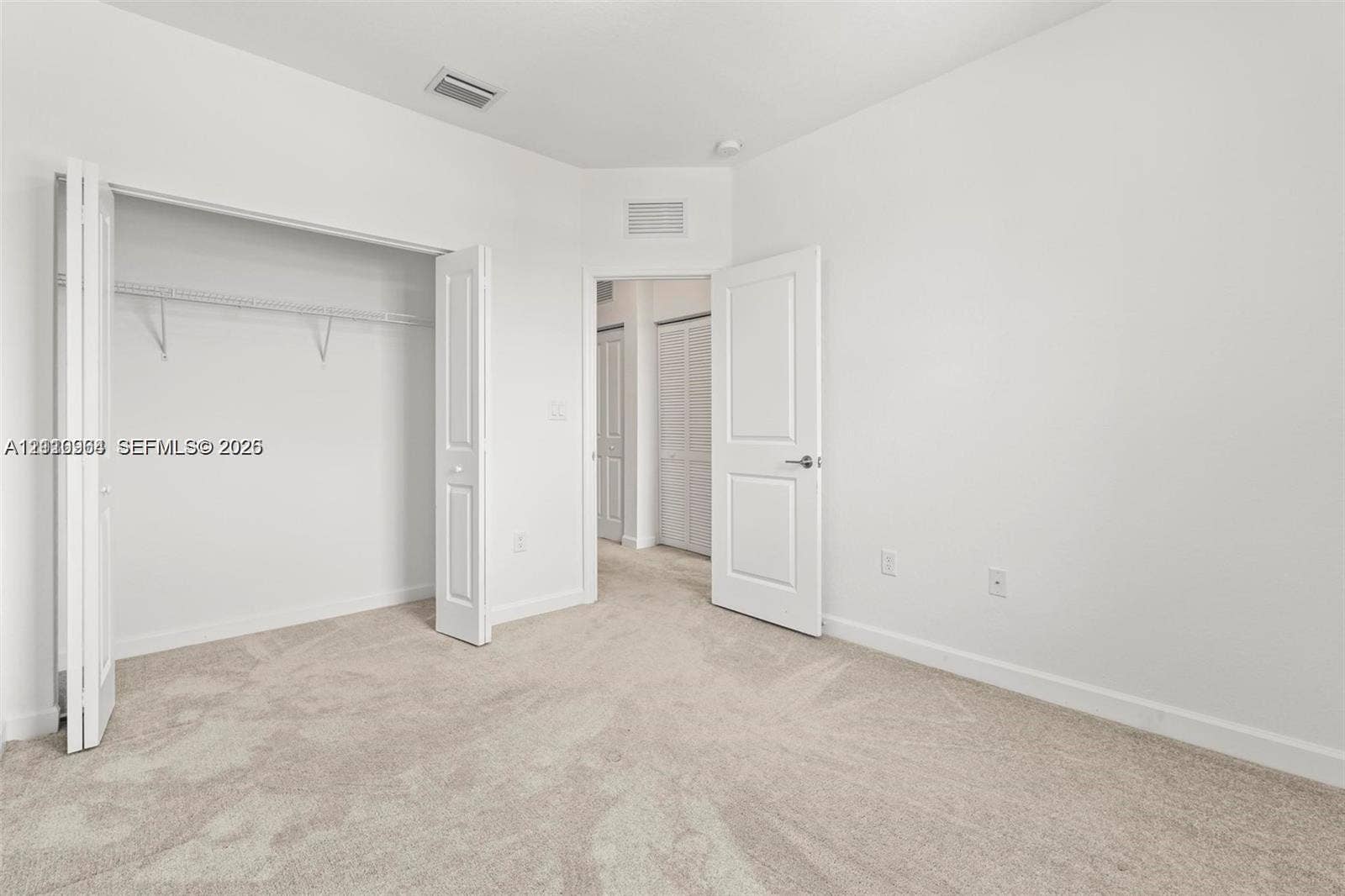 Neutral interior featuring neutral-toned carpeting, bi-fold closet doors, and multi-panel interior doors