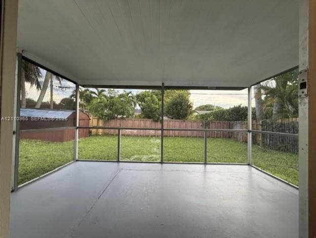 Screened-in porch featuring a painted concrete floor, solid ceiling, and metal framing