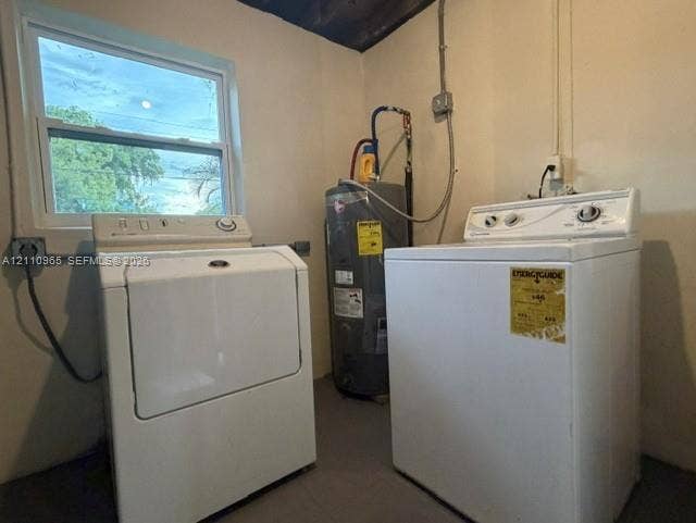 Utility area featuring an electric water heater, single-hung window, and dedicated laundry hookups