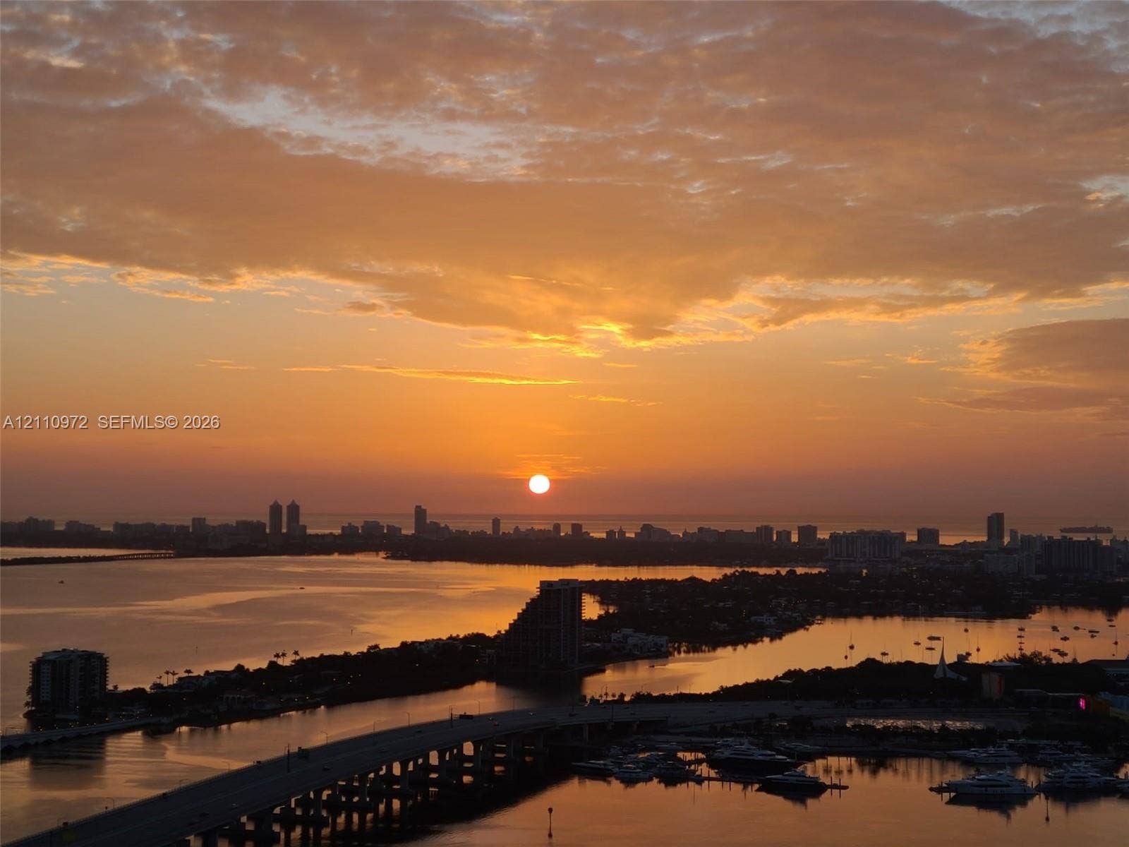 Elevated aerial perspective featuring an expansive urban skyline, coastal waterways, and open horizon