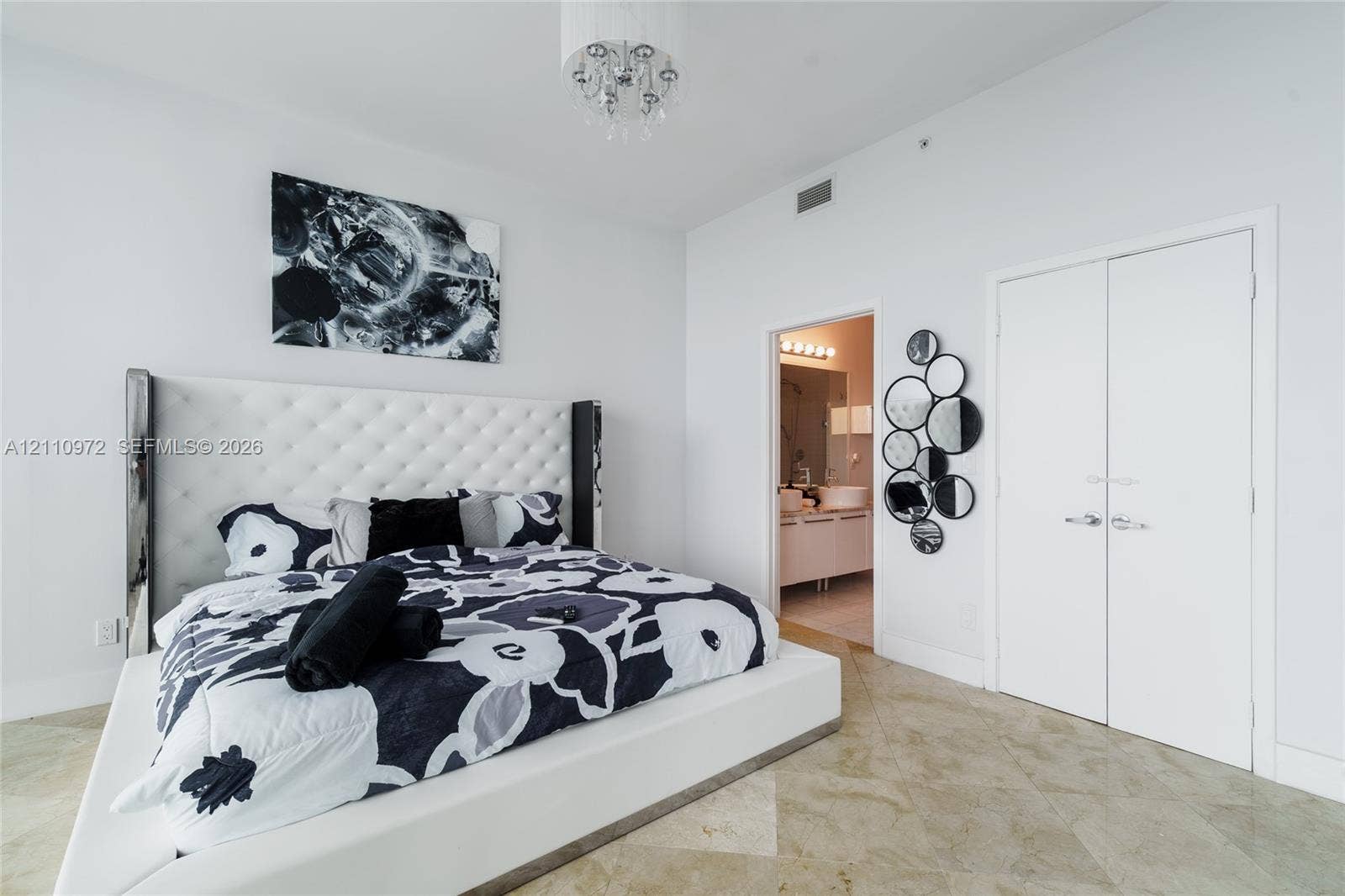 High ceilings featuring a drum-style chandelier, stone flooring, and dual-door closet