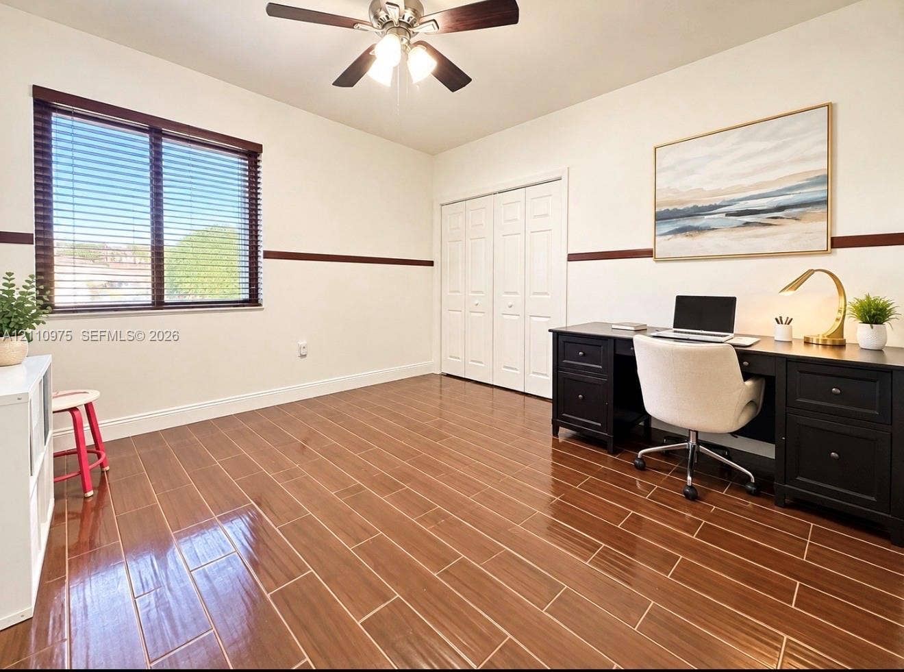 2030 NW 99th Terrace, Pembroke Pines, FL 33024 Wood-finish tile flooring, horizontal wall molding, ceiling fan with integrated lighting, and white multi-panel closet doors