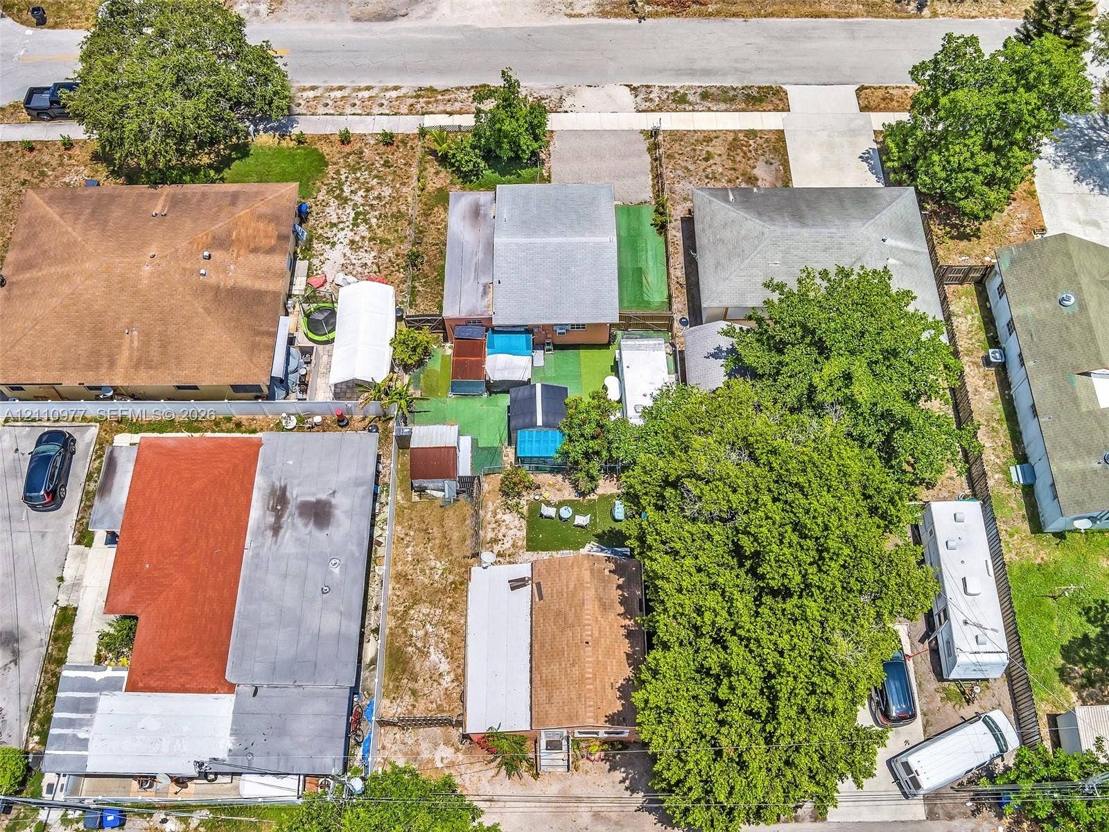 2126 Cleveland Street, #2126, Hollywood, Hollywood, FL 33020 Aerial view of the residential property featuring a composition shingle roof, mature tree coverage, and an expansive exterior lot
