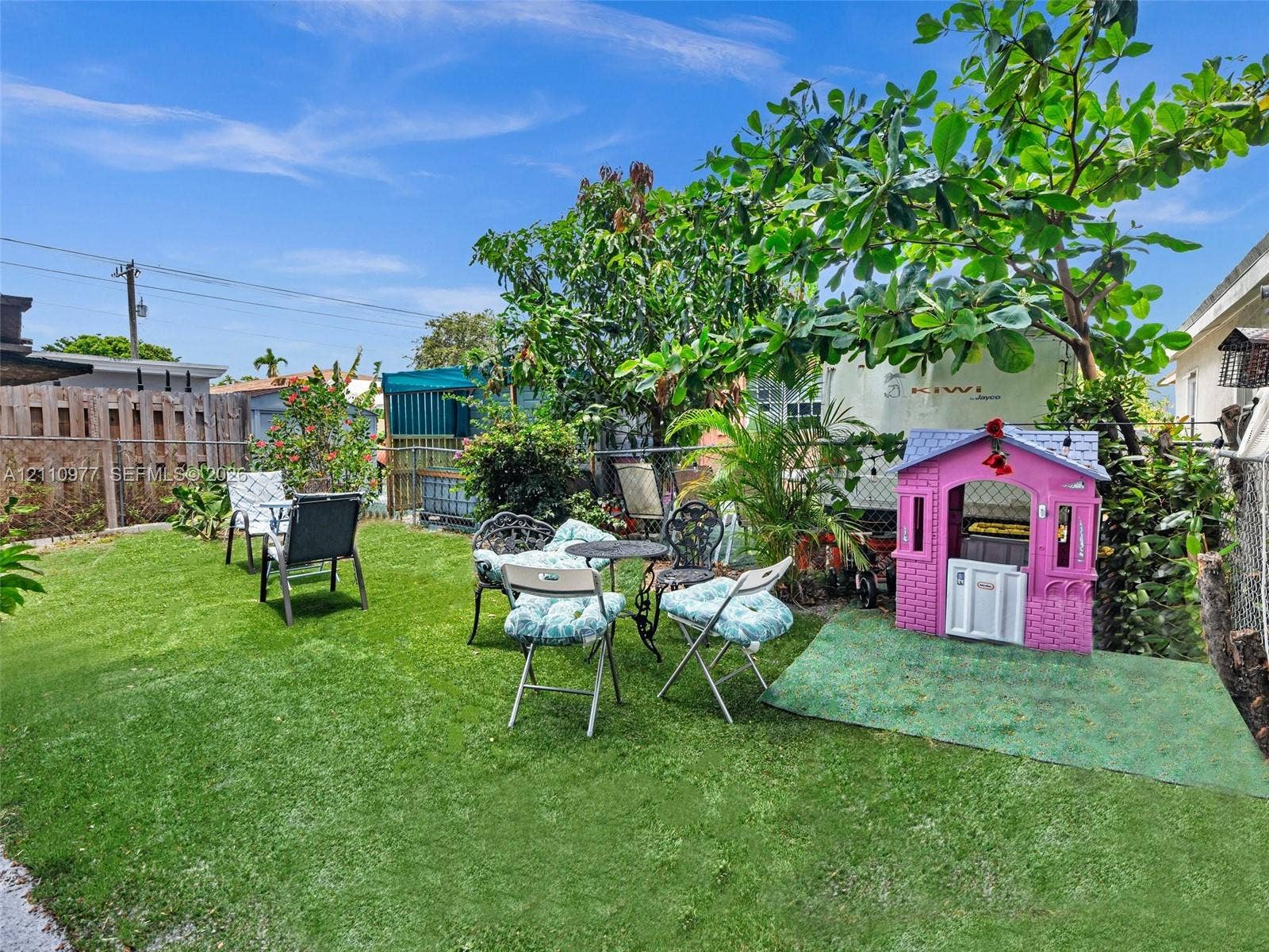 2126 Cleveland Street, #2126, Hollywood, Hollywood, FL 33020 Backyard space featuring synthetic turf, perimeter fencing, and mature trees