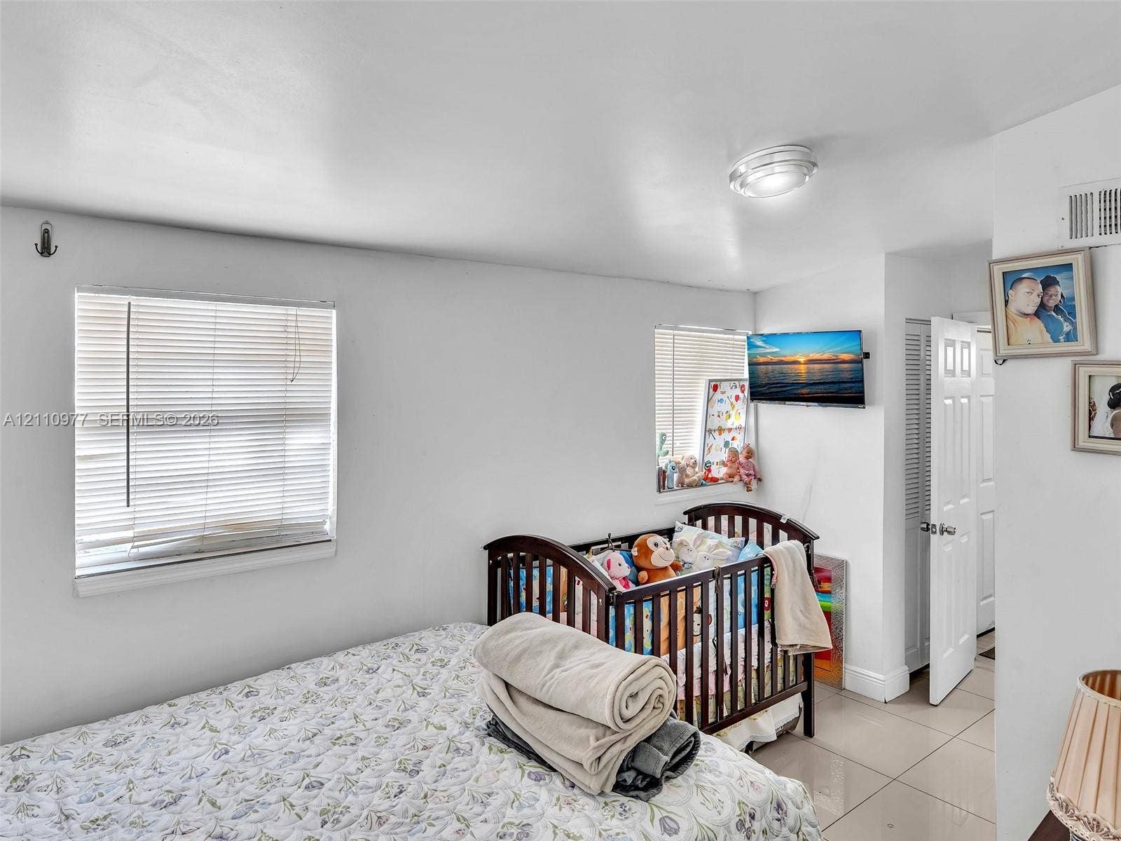2126 Cleveland Street, #2126, Hollywood, Hollywood, FL 33020 Neutral-toned room featuring large-format tile flooring, recessed ceiling lighting, two horizontal windows with fitted blinds, and a paneled interior door