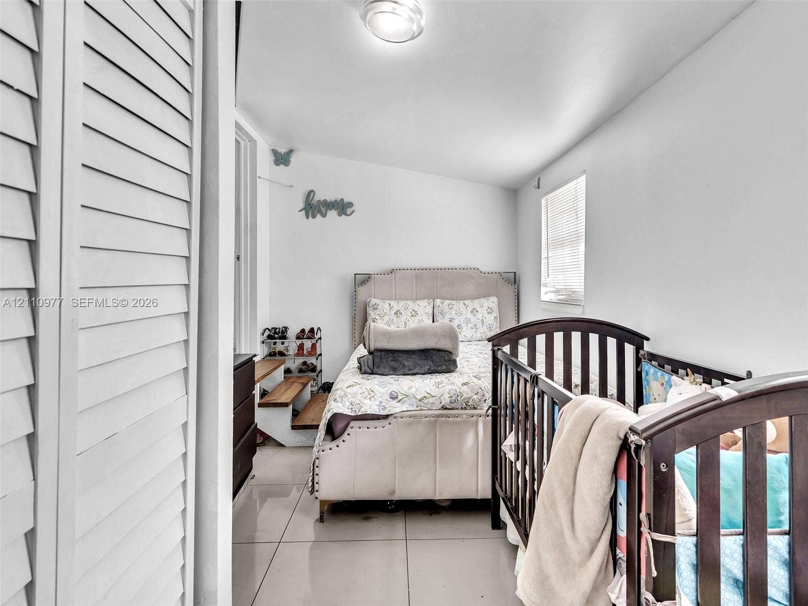 2126 Cleveland Street, #2126, Hollywood, Hollywood, FL 33020 Large-format tile flooring, white louvered closet doors, and a window with horizontal blinds