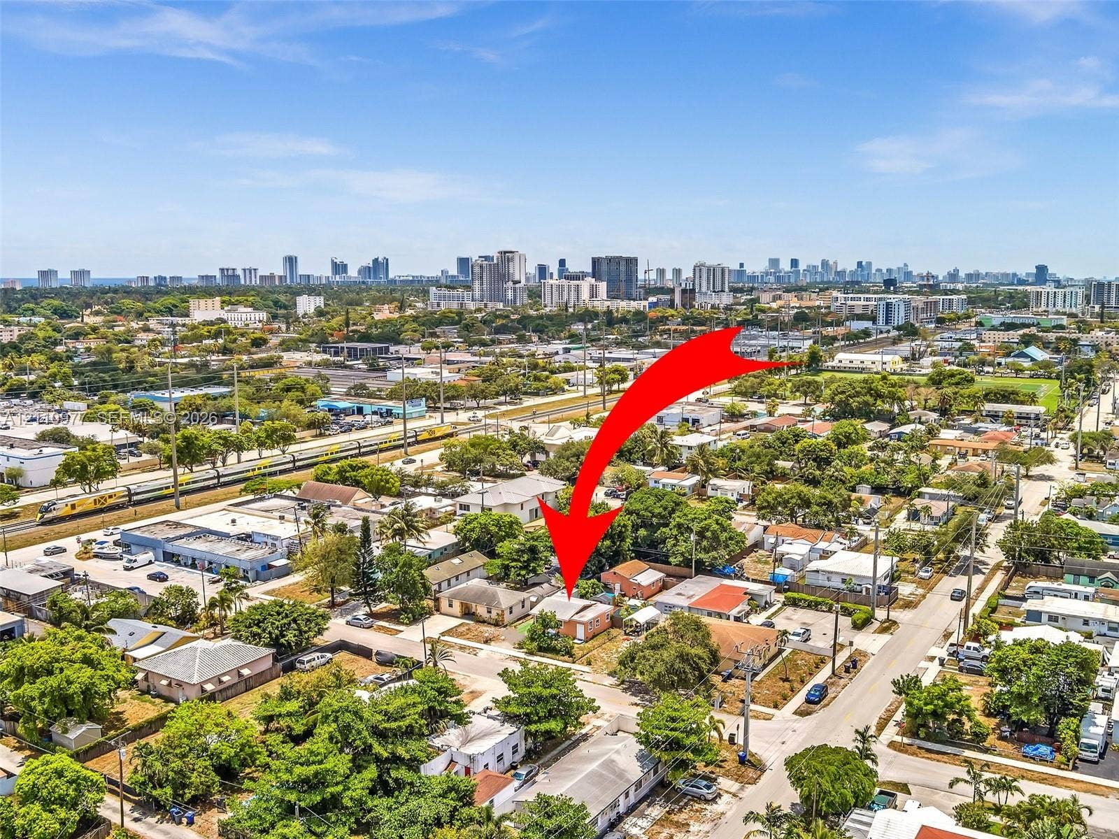 2126 Cleveland Street, #2126, Hollywood, Hollywood, FL 33020 Aerial perspective of a detached single-story residence situated within an urban environment, featuring a hip roof and established surrounding greenery
