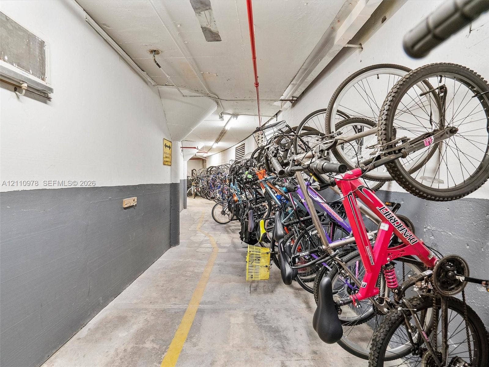 900 Bay Drive, #225, Miami Beach, FL 33141 Dedicated storage area featuring concrete flooring, two-tone painted wall surfaces, and integrated wall-mounted bicycle racking