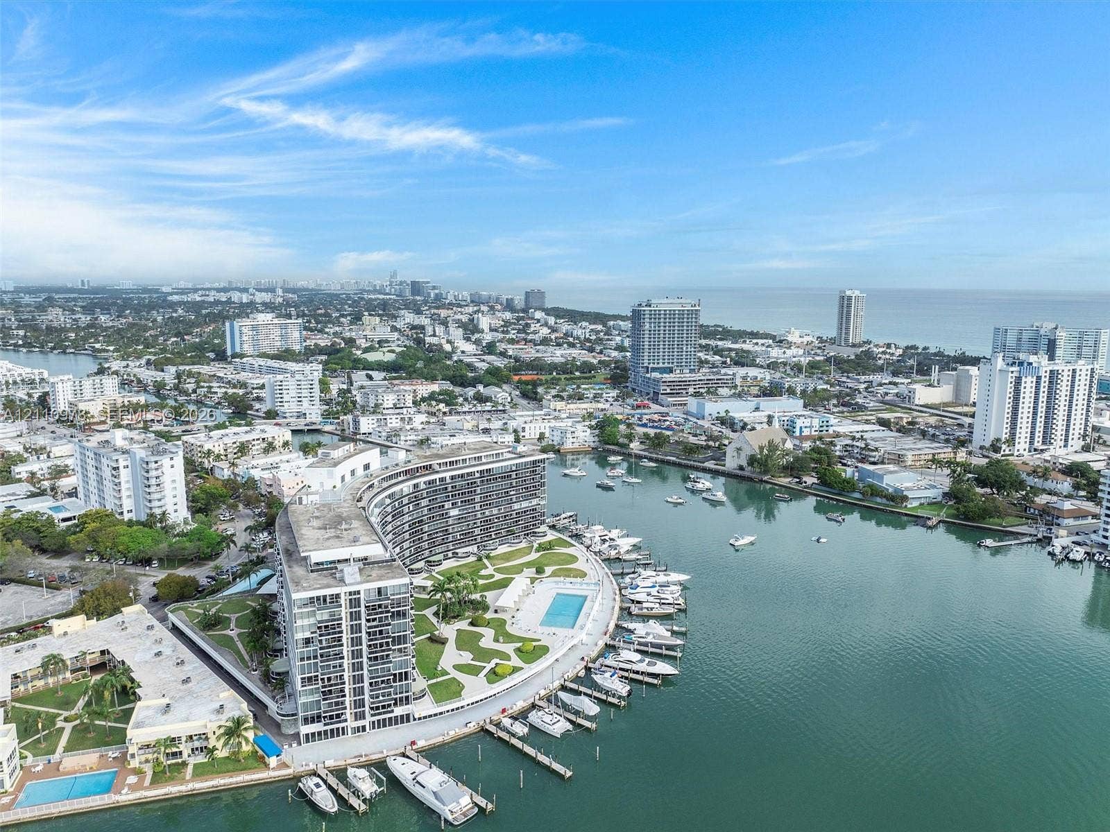900 Bay Drive, #225, Miami Beach, FL 33141 Waterfront high-rise building featuring a private marina, paved outdoor recreation area, swimming pool, and landscaped grounds