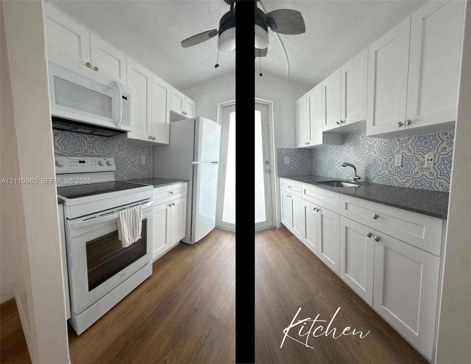Galley kitchen featuring white shaker-style cabinetry, decorative patterned backsplash, dark solid-surface countertops, wood-finish flooring, and stainless steel undermount sink