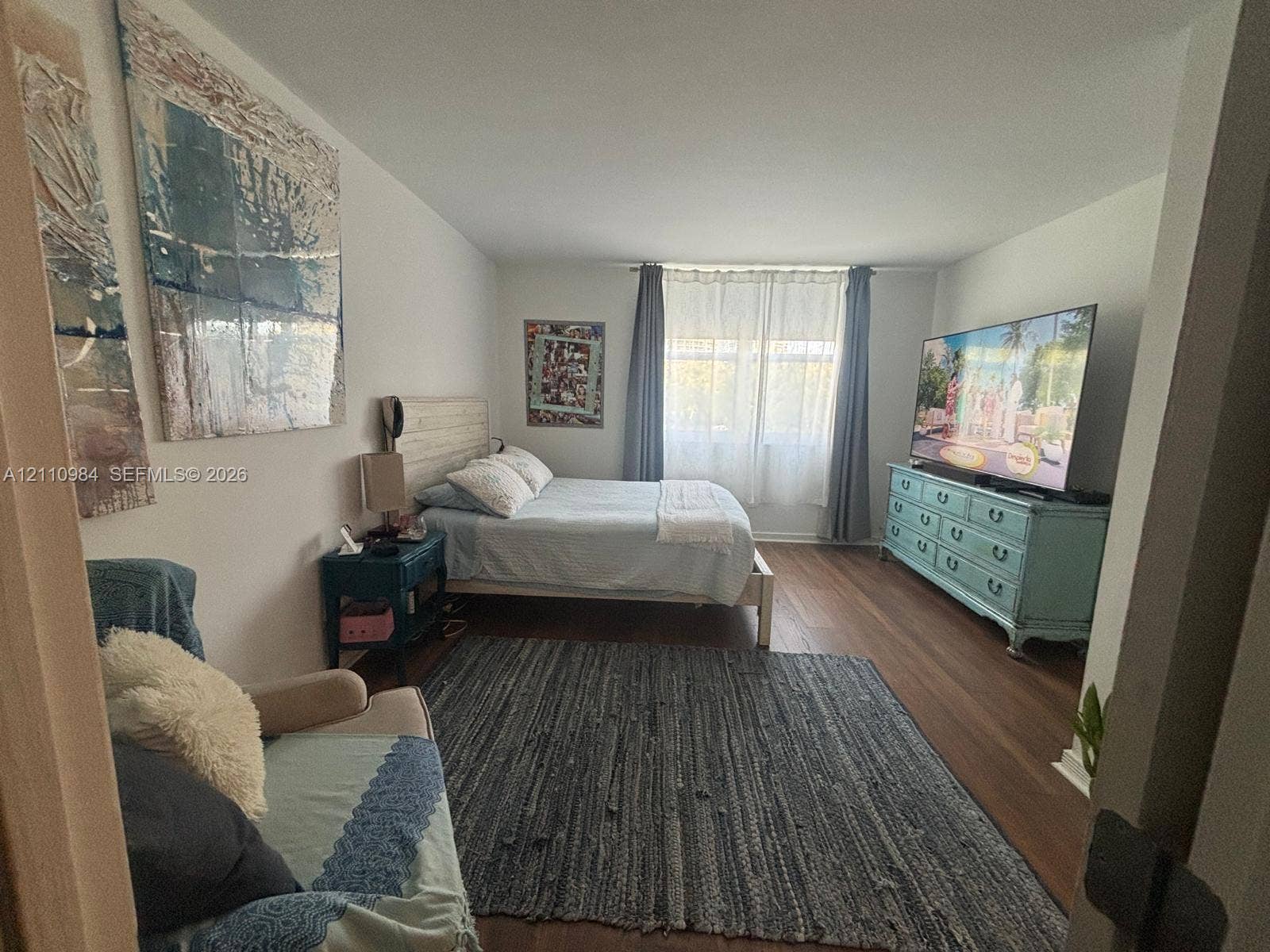 3745 NE 171st Street, #77, North Miami Beach, North Miami Beach, FL 33160 Bedroom featuring wood-finish flooring and a single window with curtain rods