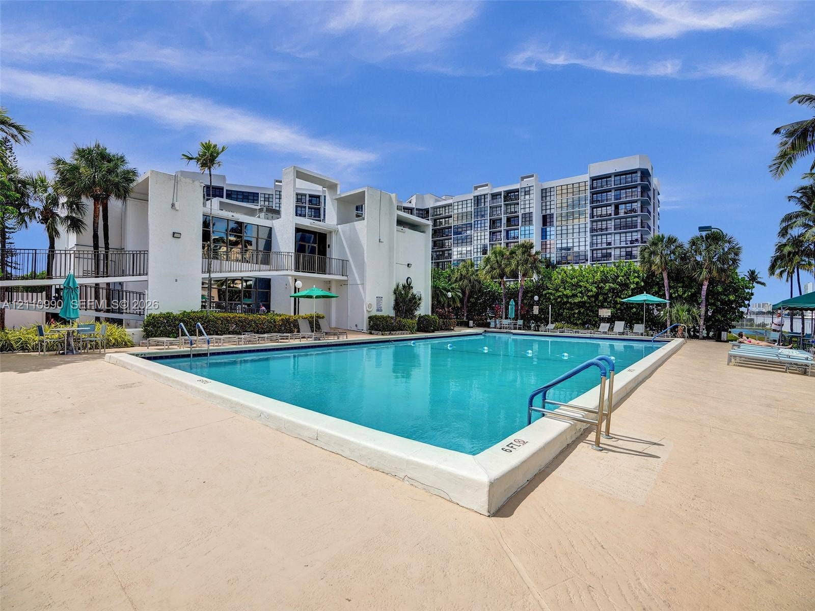 800 Parkview Drive, #131, Hallandale Beach, FL 33009 Outdoor swimming pool featuring a concrete deck, built-in metal handrails, and tropical landscaping